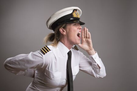 OFFICER SHOUTING AN ORDER MAY 2016 - Portrait of a female uniformed officer wearing a uniform cap shouting an orderの写真素材