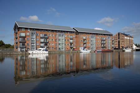 Gloucester Docks Gloucestershire England UK - October 2016 - New build apartment blocks sitting waterside on the main basin of Gloucester Docksのeditorial素材