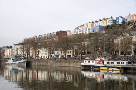 Colourful homes line the waterfront of the floating harbour in Bristol England UKのeditorial素材