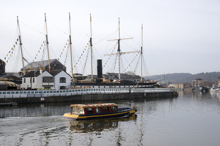 A pedestrian ferry passing SS Great Britain dock on the floating harbour in Bristol Avon England UKのeditorial素材