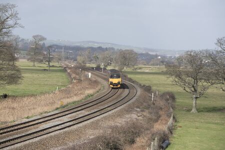 A First Great Western company passenger train passing through English countryside south of Exeter in...