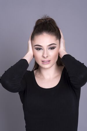 Young woman holding hands over her earsの写真素材