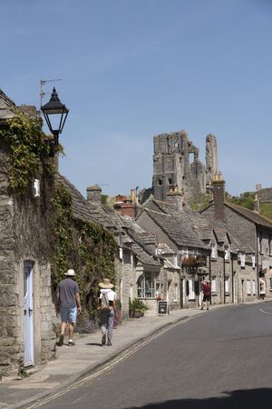Quaint street in Corfe Castle Dorset England UK overlooked by the castle ruins.のeditorial素材