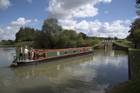 Narrowboat entering the lower lock of the Caen Flight of Locks on the Kennet & Avon Canal in Devizes Wiltshire UKのeditorial素材