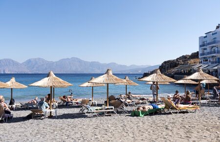 Agios Nikolaos, Crete, Greece, Tourists on the Kitroplatia municipal beach close to the town centre. October 2017のeditorial素材