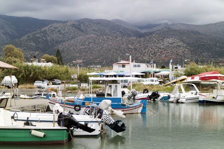 The small fishing boat habour at Malia, Crete,Greece, with a backdrop of mountains.のeditorial素材