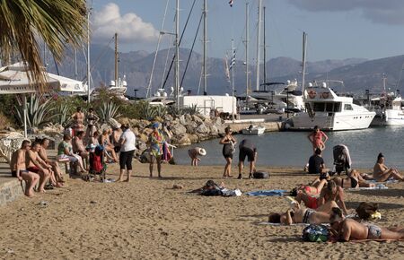 Agios Nikolaos, Crete, Greece. Holidaymakers on the Municipal beach Ammos ajoining the marina. October 2017のeditorial素材
