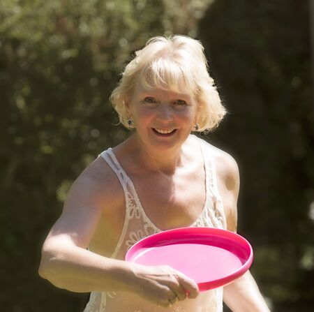 Mature woman throwing a plastic discの写真素材