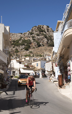 Kritsa mountain village near Agios Nikolaos, Crete, Greece. 2017. Woman cycle rider passing through Kritsaのeditorial素材