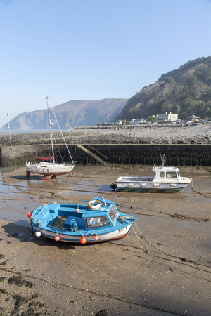 Lynmouth, North Devon, England, UK. March 2019. Lynmouth pier and  small boats on the West Lyn River at low tide where it meets the Bristol Channel.のeditorial素材