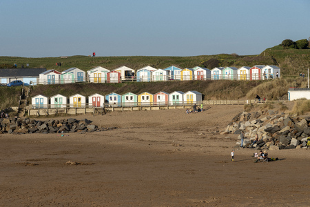 Bude, Cornwall, England, UK. March 2019. Beach huts overlook the beach in Bude a north Cornwall holiday resort.のeditorial素材