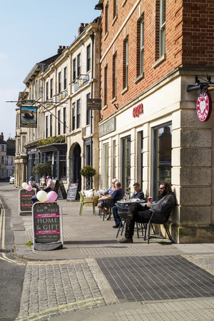 Devizes, Wiltshire, England, UK. March 2019.  Customers seated outside a pub and coffee shop on the main street.のeditorial素材