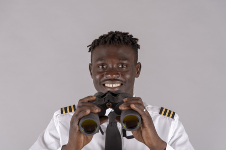 Young airline pilot using a pair of binoculars.の写真素材