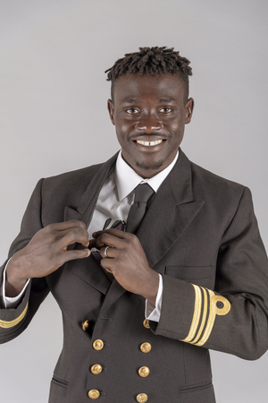 Lieutenant Commander wearing uniform of the South African Navy. Putting sunglasses into an inside pocket.の写真素材