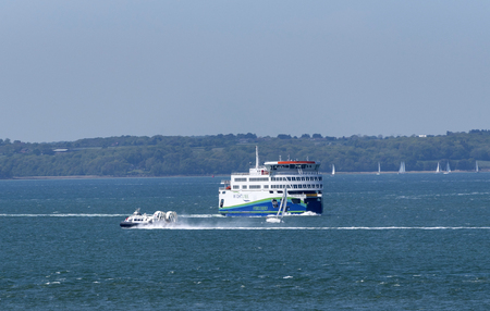 Portsmouth, England, UK, May 2019. Background of the Isle of Wight, with a ferry, hovercraft and a yacht all underway crossing The Solent a stretch of water between the mainland and the IOWのeditorial素材
