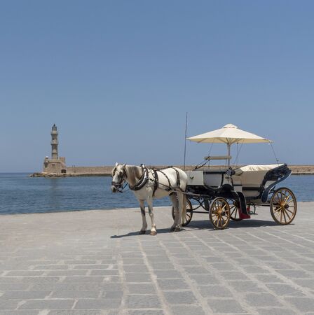 Chania, Crete, Greece, June 2019. Horse drawn carriage waiting on the Old Venetion Harbour in Chania...
