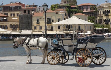 Chania, Crete, Greece, June 2019. Horse drawn carriage waiting on the Old Venetion Harbour in Chania to take passengers on a ride.のeditorial素材