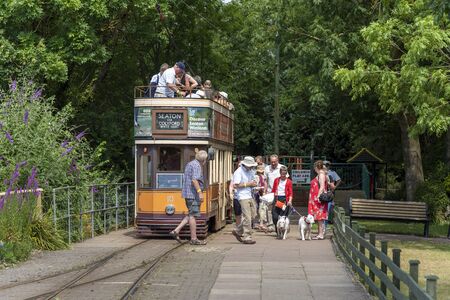 Colyford, Devon, England, UK. July 2019. Seaton Tramway. Electric tramcar  10 which dates from 2006. Passengers alight at Colyford Station on a trip from Seaton, Devon.のeditorial素材