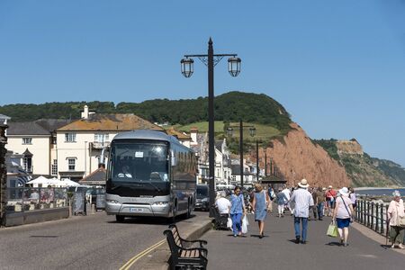 Sidmouth, Devon, England, UK. July 2019. Motor coach on the seafront at Sidmouth a popular holiday resort in East Devon.のeditorial素材