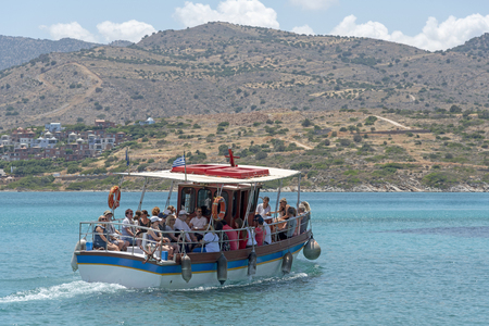Crete, Greece. June 2019. Small passenger boat with tourists underway on  the Gulf of Mirabello off the Cret coast.のeditorial素材