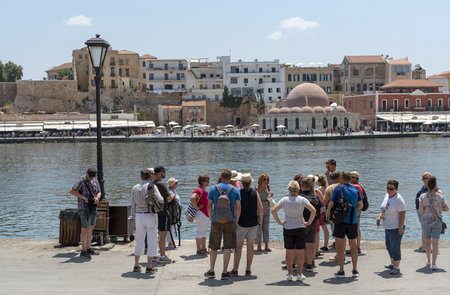 Chania, Crete, Greece. June 2019. Tourist group visiting the Chania old town and Venetian Harbour.のeditorial素材