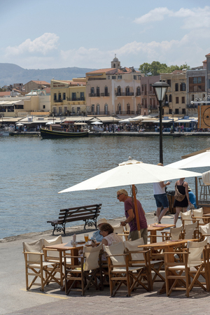Chania, Crete, Greece. June 2019. Tourists visiting the Chania old town and Venetian Harbour. Waterfront restaurant.のeditorial素材