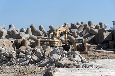 Port of Rethymno, Eastern Crete, Greece. September 2019.  Crushing old concrete for redevelopment of...