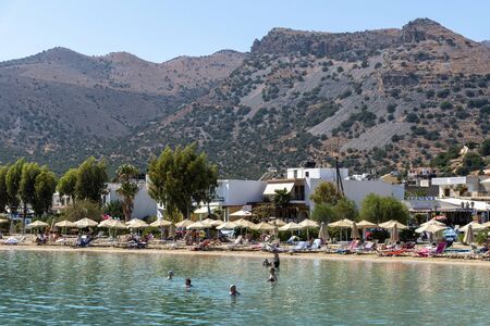 Elounda, northern Crete, Greece. October 2019. The beach  at Eloundawith a backdrop of Mountains.のeditorial素材