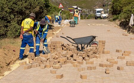 Rooiels, Western Cape, South Africa. December 2019. Workers laying a brick road in the small hamlet of Rooiels.のeditorial素材