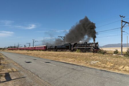 Hermon, Swartland, South Africa. December 2019. Oil burner vintage black locomotive seen passing...