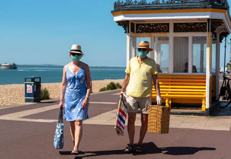 Southsea, Portsmouth, England, UK. May 2020.  Couple visit the seaside town of Southsea wearing masks for protection during the Covid-19 outbreak.のeditorial素材