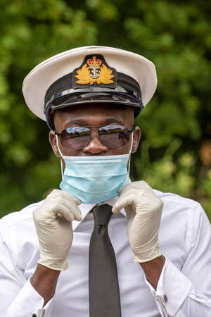Hampshire, England, UK. 2020. A naval officer wearing surgical gloves and a face mask during the Covid-19 outbreak in the UKの写真素材