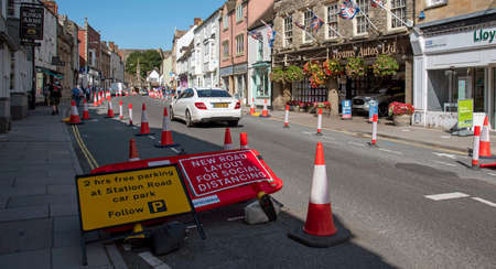 Malmesbury, Wiltshire, England, UK. 2020, Social distancing traffic cones and signage in the main...