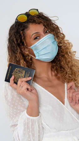 England, UK. 2021. Woman holding a new blue UK passport and wearing a mask during outbreakの写真素材