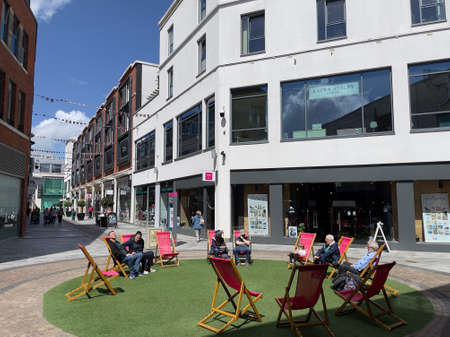 Newbury, berkshire, England, UK. 2022. Deck chairs on grass for use by shoppers in the town Centre.のeditorial素材