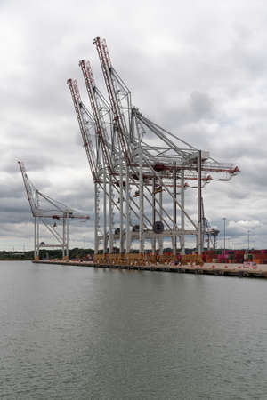 Southampton, England, UK. 2022. Large cranes waterside at a container ship terminal in southern England.の写真素材