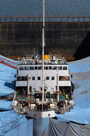 Falmouth, Cornwall, England, UK. 2022.  The historic steamship Shieldhall in dry dock surrounded by tarpaulins whilst work is carried out on the hull of this shipの写真素材