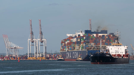 Southampton, England, UK. 2022. Large container ship approaching DP World Southamton container port and the Witonia a bunkering vessel closer to camera.のeditorial素材