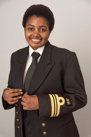 Young African woman in uniform posing in studio.