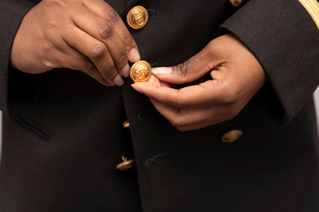 Closeup of a woman wearing a uniform jacket  . Airline pilot buttoning jacket.