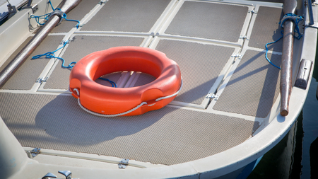orange lifebuoy on deck of a white boatのeditorial素材