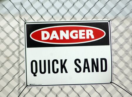 signage warning against quick sand in development areaの写真素材