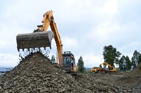 Excavator filling a dump truck at a construction site in Westland