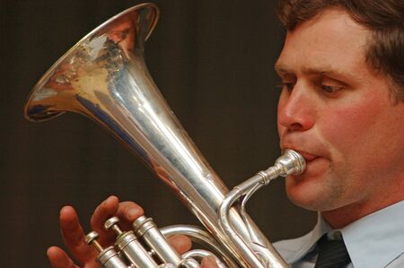 Brass band member playing a trumpet in live performance