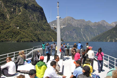 MILFORD SOUND, NEW ZEALAND, JANUARY 8: Visitors enjoy the sights from a tourist launch on 8-1-2011 at Milford Sound in New Zealand. Milford Sound is one of the country's  favourite tourist destinations. のeditorial素材