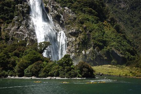 MILFORD SOUND, NEW ZEALAND, JANUARY 8: Visitors enjoy the sights of Bowen Falls from sea kayaks on 8-1-2011 at Milford Sound in New Zealand. Milford Sound is one of the countryのeditorial素材