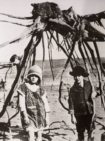 SOUTH AUSTRALIA circa 1930: Unidentified children stand before a tree stump exposed by soil erosion circa 1930 in South Australia. Soil erosion continues to cost farmers millions of dollars.のeditorial素材