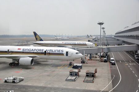 SINGAPORE, FEBRUARY 13: Commercial airliners wait for passengers at Changi International Airport on February 13, 2009 in Singapore.のeditorial素材