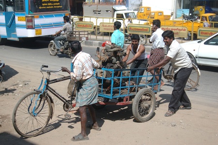 TAMIL NADU, INDIA, circa 2009: Men move a large motor on a flimsy bicycle trailer, circa 2009 in...