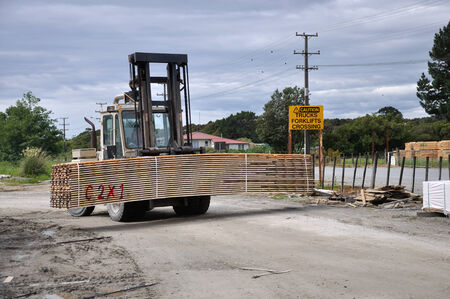A forklift carries a pack of sawn Pinus radiata boards at a sawmillの写真素材